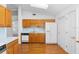 Functional kitchen featuring wooden cabinets, white appliances, and a practical layout at 36545 Scottsdale Dr, Grand Island, FL 32735