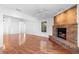 Inviting living room featuring wood floors, a brick fireplace, and a ceiling fan for added comfort and style at 36545 Scottsdale Dr, Grand Island, FL 32735