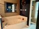 A bathtub with jacuzzi jets is shown in a spacious bathroom with striped wallpaper at 3708 Fairfield Dr, Clermont, FL 34711