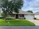 Charming home featuring a well-manicured lawn, tidy landscaping, and a two-car garage with a brick paver driveway at 3708 Fairfield Dr, Clermont, FL 34711