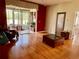 Spacious living room with hardwood floors, glass coffee table, and access to the screened lanai at 3708 Fairfield Dr, Clermont, FL 34711