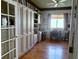 Home office with hardwood floors, built-in shelving, and a bright window at 3708 Fairfield Dr, Clermont, FL 34711