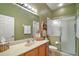 Well-lit bathroom featuring a glass shower, a vanity, and an earth-tone color scheme at 3828 Arbordale Ct, Leesburg, FL 34748