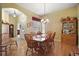Inviting dining room with wood table, chairs, chandelier, and hardwood flooring at 3828 Arbordale Ct, Leesburg, FL 34748