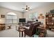 Comfortable living room featuring leather seating, a ceiling fan, and lots of natural light at 3828 Arbordale Ct, Leesburg, FL 34748