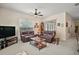 Spacious living room with ceiling fan, sliding glass doors and comfortable leather seating at 3828 Arbordale Ct, Leesburg, FL 34748