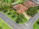 Aerial shot showcases a home nestled within a golf course community, lush greenery, mature trees, and a paved driveway at 383 Kilmer Way, The Villages, FL 32162