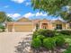 Beautiful single-story home featuring a well-manicured lawn, lush landscaping, and a spacious three-car garage at 383 Kilmer Way, The Villages, FL 32162