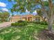 Beautiful single-story home featuring a well-manicured lawn, lush landscaping, and a spacious three-car garage at 383 Kilmer Way, The Villages, FL 32162