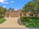 Charming home featuring a well-manicured lawn, three car garage, and mature landscaping at 383 Kilmer Way, The Villages, FL 32162