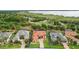 Aerial view of a luxurious home with a red tile roof surrounded by lush greenery and a lake at 38716 Oak Place Ct, Lady Lake, FL 32159