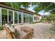 Expansive backyard patio featuring comfortable seating, a retractable glass doors, and lush landscaping at 38716 Oak Place Ct, Lady Lake, FL 32159
