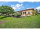 Well-manicured backyard with a spacious lawn, brick patio, and mature trees, offering privacy at 38716 Oak Place Ct, Lady Lake, FL 32159