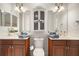 Bathroom featuring dual vanities, decorative light fixtures and a central cabinet for storage at 38716 Oak Place Ct, Lady Lake, FL 32159