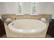 Bathroom with a soaking tub that features tile surround and stylish fixtures for a luxurious bathing experience at 38716 Oak Place Ct, Lady Lake, FL 32159