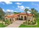 Stunning Mediterranean-style home with a red tile roof, arched entryways, and a meticulously landscaped front yard at 38716 Oak Place Ct, Lady Lake, FL 32159