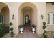 Elegant front porch with brick pavers, decorative planters, and arched entry leading to the front door at 38716 Oak Place Ct, Lady Lake, FL 32159