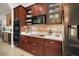 Gourmet kitchen with dark wood cabinets, stainless steel appliances, and a tile backsplash at 38716 Oak Place Ct, Lady Lake, FL 32159