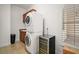 Bright laundry room featuring a stacked washer/dryer and a built-in wine cooler at 38716 Oak Place Ct, Lady Lake, FL 32159
