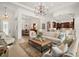 Spacious living room with tile floors, high ceilings, elegant chandelier and seamless flow to kitchen and dining areas at 38716 Oak Place Ct, Lady Lake, FL 32159