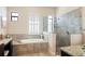 Spa-like bathroom featuring a soaking tub, glass-enclosed shower, and dual windows at 39505 Hillrise Ln, Lady Lake, FL 32159