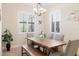 Dining room showcasing a chandelier, plantation shutters, and a modern farmhouse-style wooden table with bench seating at 39505 Hillrise Ln, Lady Lake, FL 32159
