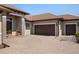 Home featuring a three car garage with a brick paver driveway, stone accents, and lush landscaping at 39505 Hillrise Ln, Lady Lake, FL 32159