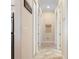 Hallway featuring tiled flooring, neutral paint, a decorative wall hanging and multiple access doors at 39505 Hillrise Ln, Lady Lake, FL 32159