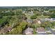 Aerial view of the neighborhood showing mature trees, community landscaping, and multiple homes in a well-maintained area at 411 Loma Paseo Dr, The Villages, FL 32159