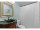 Bathroom featuring decorative mirror, vanity, sink, toilet and bathtub with white curtain at 411 Loma Paseo Dr, The Villages, FL 32159