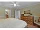Comfortable bedroom with a decorative dresser, smooth walls, and soft carpet flooring at 411 Loma Paseo Dr, The Villages, FL 32159