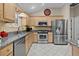 Well-lit kitchen with stainless steel appliances, granite counters and a stainless sink creating a modern feel at 411 Loma Paseo Dr, The Villages, FL 32159