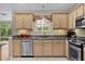 Well-lit kitchen featuring granite countertops, stainless steel appliances, and neutral-toned cabinetry at 411 Loma Paseo Dr, The Villages, FL 32159