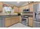 Modern kitchen with stainless steel appliances, granite countertops, and bright lighting, offering a functional cooking space at 411 Loma Paseo Dr, The Villages, FL 32159
