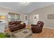 Inviting living room with hardwood floors, vaulted ceiling, and comfortable leather seating by the fireplace at 411 Loma Paseo Dr, The Villages, FL 32159