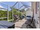 Screened patio with outdoor seating, a grill, and string lights, perfect for entertaining and relaxing outdoors at 411 Loma Paseo Dr, The Villages, FL 32159