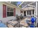 Covered patio with outdoor dining set, comfortable seating, and backyard views, ideal for enjoying outdoor meals at 411 Loma Paseo Dr, The Villages, FL 32159