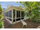Exterior view of the sunroom, palm tree, and outdoor bench, showcasing the relaxing and peaceful atmosphere at 411 Loma Paseo Dr, The Villages, FL 32159