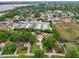 Aerial view of a neighborhood with lush greenery, including homes and commercial business storage units on a lake at 4145 Dora Wood Dr, Mount Dora, FL 32757