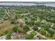 Panoramic aerial shot showcasing a neighborhood with lush green trees and residential homes on a lake at 4145 Dora Wood Dr, Mount Dora, FL 32757
