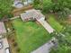 Aerial view of a home with a large, well-maintained lawn, a long driveway, and mature trees at 4145 Dora Wood Dr, Mount Dora, FL 32757