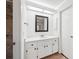 Bathroom featuring a shower, vanity with white cabinets, and a framed mirror at 4145 Dora Wood Dr, Mount Dora, FL 32757