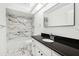 Updated bathroom featuring modern fixtures, marble tile, and a black granite countertop at 4145 Dora Wood Dr, Mount Dora, FL 32757