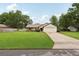 Well-maintained single-story home with a spacious front yard, mature trees, and a driveway leading to the garage at 4145 Dora Wood Dr, Mount Dora, FL 32757