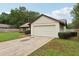 Exterior view of a home featuring a two-car garage, a brick pathway, and nicely trimmed landscaping at 4145 Dora Wood Dr, Mount Dora, FL 32757
