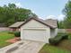 Attached two car garage, trimmed shrubbery and brick path add to the home's curb appeal at 4145 Dora Wood Dr, Mount Dora, FL 32757