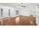 Bright living room features wood floors, a ceiling fan, and a large window for natural light at 4145 Dora Wood Dr, Mount Dora, FL 32757