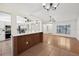 Open-concept living room and kitchen with tile and wood floors, chandelier, and breakfast bar at 4145 Dora Wood Dr, Mount Dora, FL 32757