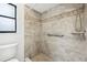Updated tiled shower with a grab bar and built-in shower caddy at 4145 Dora Wood Dr, Mount Dora, FL 32757