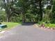 Gravel driveway winding through a lush, green landscape with mature trees providing ample shade at 4746 Cr 300, Lake Panasoffkee, FL 33538